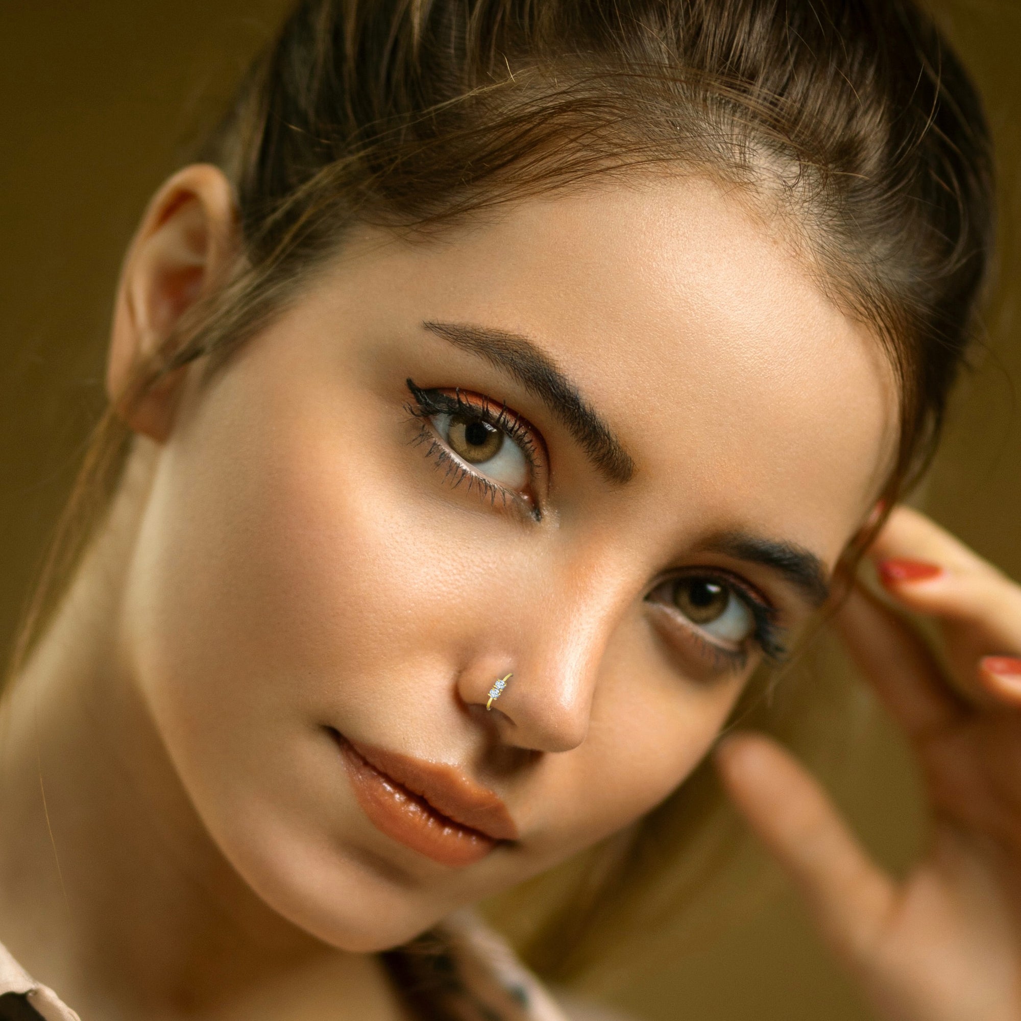 Comet Busters golden hoop nose stud featuring a delicate circular ring design with sparkling clear crystal accents set at the top for an elegant and stylish look.