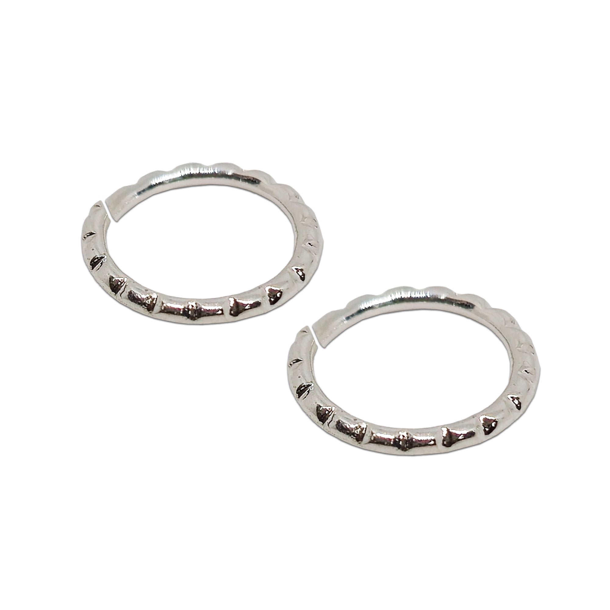 Comet Busters silver-toned embossed pattern nose stud pair with delicate decorative detailing on a white background.
